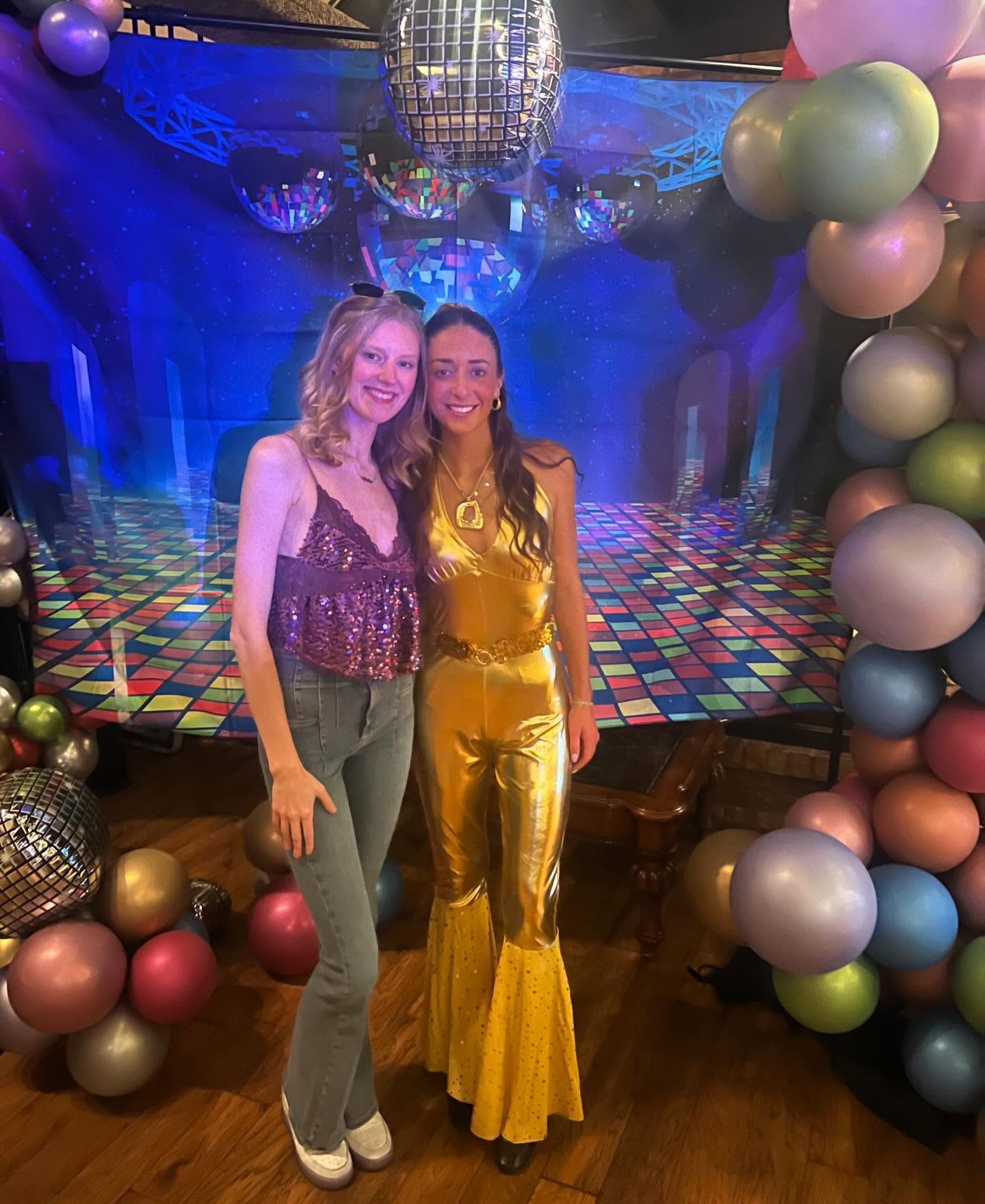 Two guests in colorful retro outfits at a DJ Russ Fritz dance event